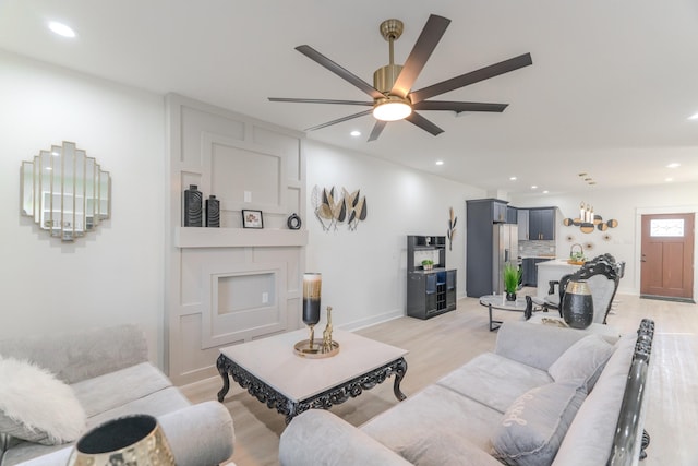 living room featuring ceiling fan and light wood-type flooring