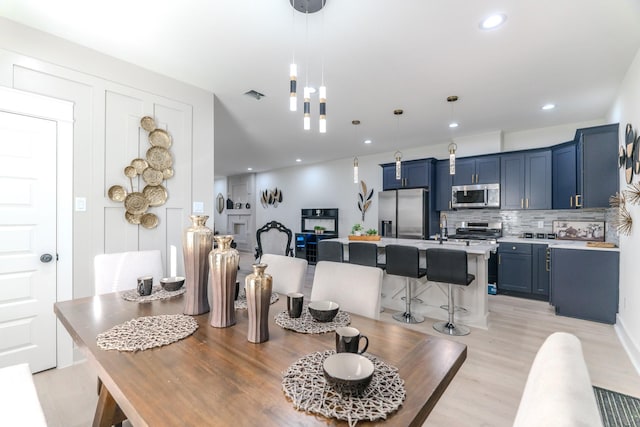 dining space with light wood-type flooring and sink