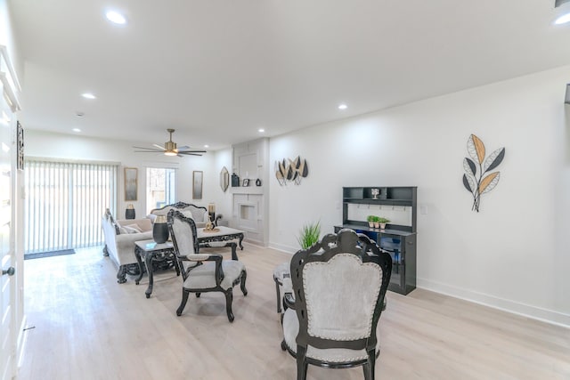 living room with ceiling fan and light wood-type flooring