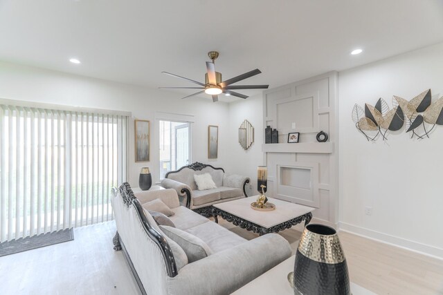 living room with ceiling fan and light hardwood / wood-style flooring