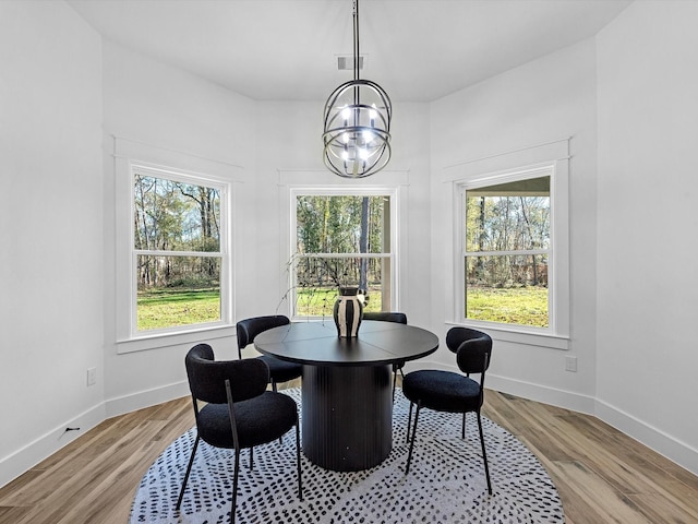 dining area with an inviting chandelier, light hardwood / wood-style flooring, and a wealth of natural light