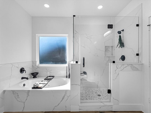 bathroom featuring shower with separate bathtub