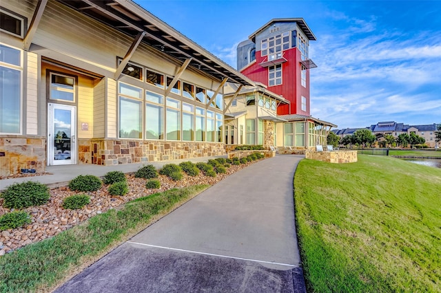 view of community with a water view and a lawn