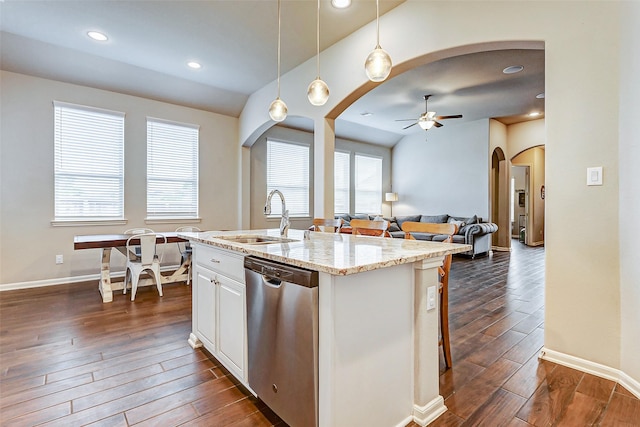 kitchen with pendant lighting, sink, stainless steel dishwasher, light stone counters, and white cabinetry