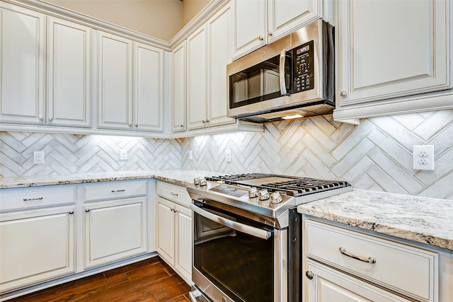 kitchen with decorative backsplash, dark hardwood / wood-style flooring, light stone counters, and stainless steel appliances