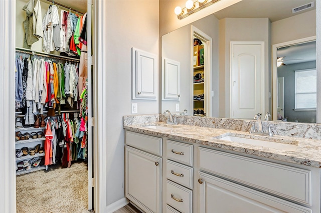 bathroom with ceiling fan and vanity