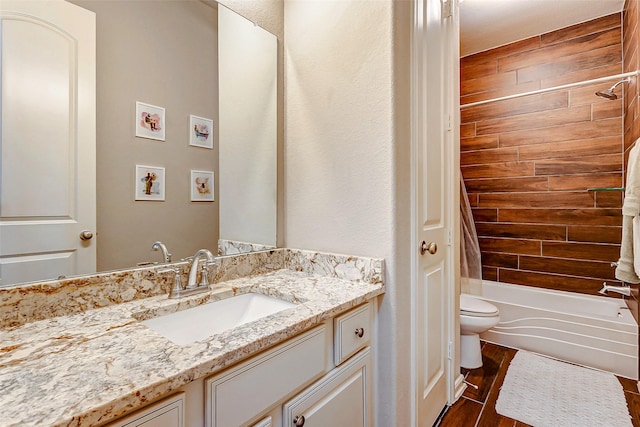 full bathroom featuring hardwood / wood-style flooring, vanity, toilet, and tiled shower / bath