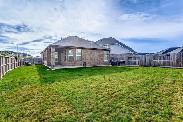 back of house with a yard and a patio area