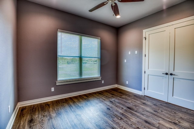 empty room featuring ceiling fan and dark wood-type flooring