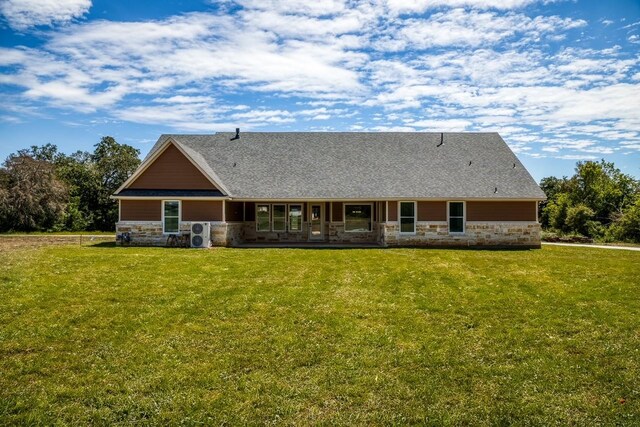 back of property with a yard and ac unit