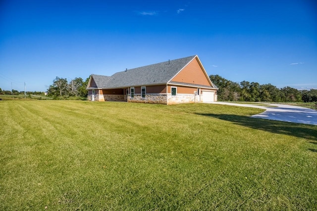 rear view of property featuring a garage and a yard