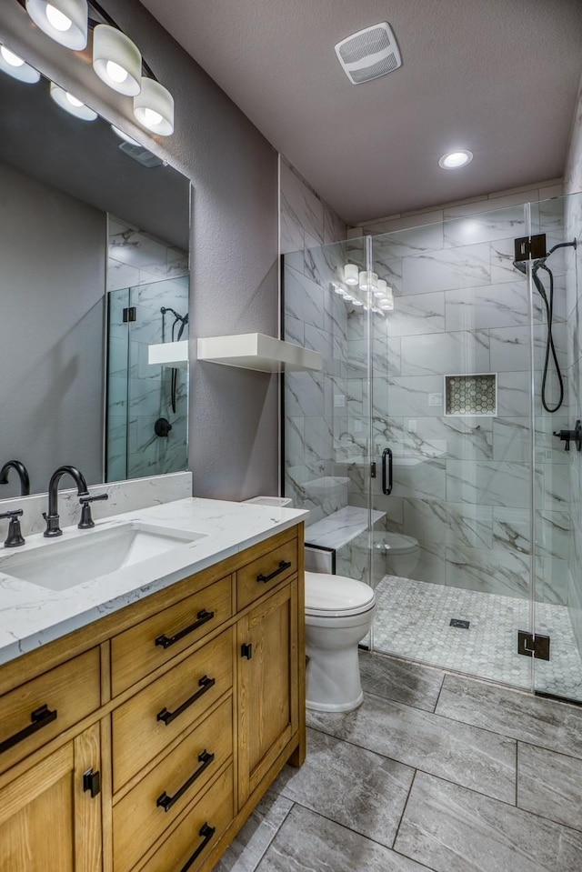 bathroom with vanity, toilet, and an enclosed shower