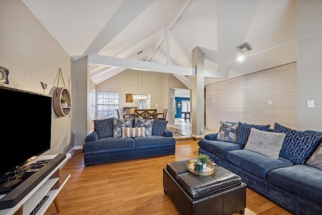 living room featuring wood-type flooring and vaulted ceiling with beams