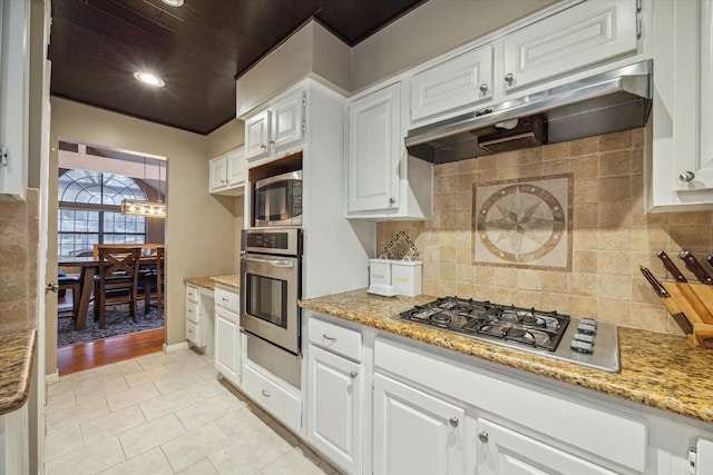 kitchen featuring backsplash, white cabinets, light tile patterned floors, light stone counters, and stainless steel appliances