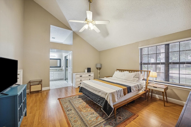 bedroom featuring light wood-type flooring, ensuite bathroom, high vaulted ceiling, and ceiling fan