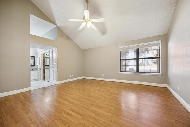 unfurnished living room featuring light hardwood / wood-style flooring, vaulted ceiling, and ceiling fan