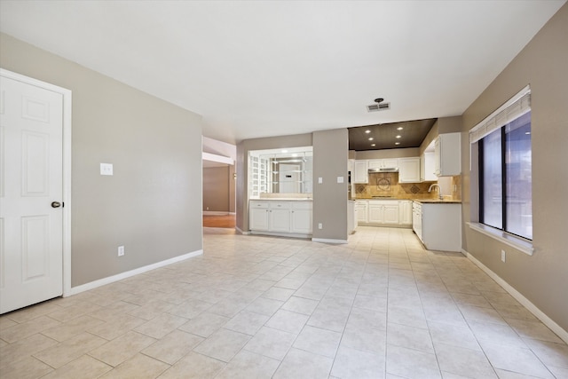 unfurnished living room with sink and light tile patterned flooring