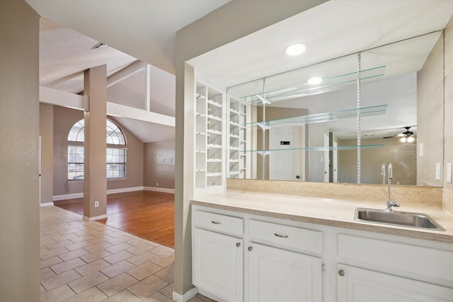 bar featuring white cabinets, light tile patterned floors, ceiling fan, and sink