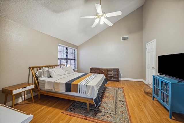 bedroom with hardwood / wood-style flooring, ceiling fan, and high vaulted ceiling