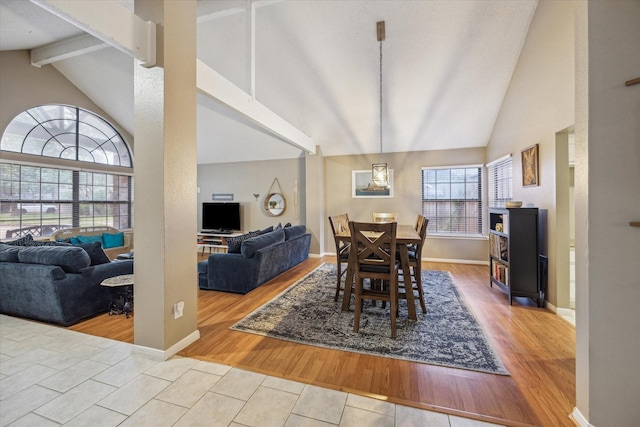 tiled dining room with vaulted ceiling with beams and plenty of natural light