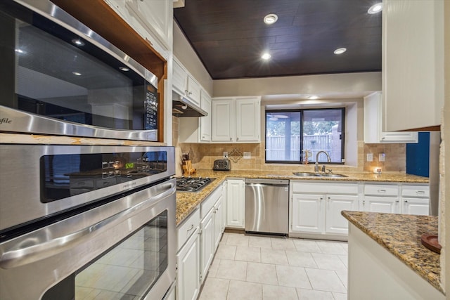 kitchen with light stone countertops, sink, white cabinetry, and stainless steel appliances