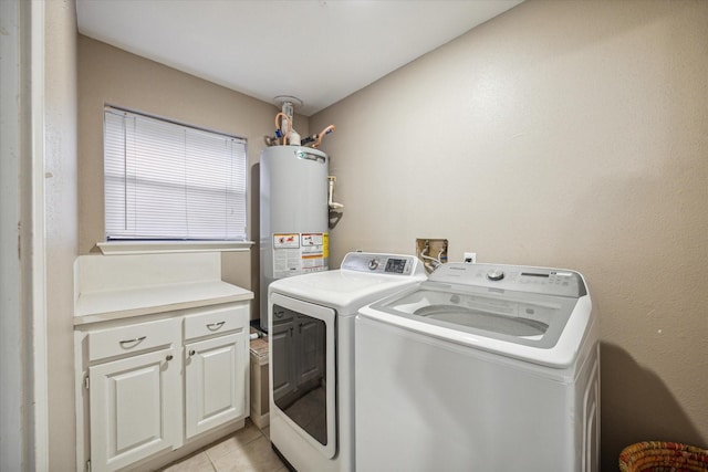 washroom with separate washer and dryer, water heater, light tile patterned floors, and cabinets