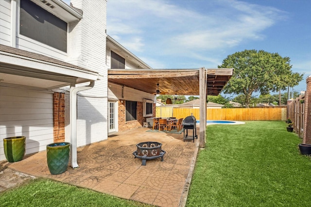 view of patio / terrace featuring a fenced in pool, a fire pit, and ceiling fan