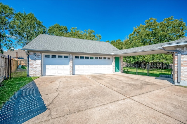 garage with driveway and fence