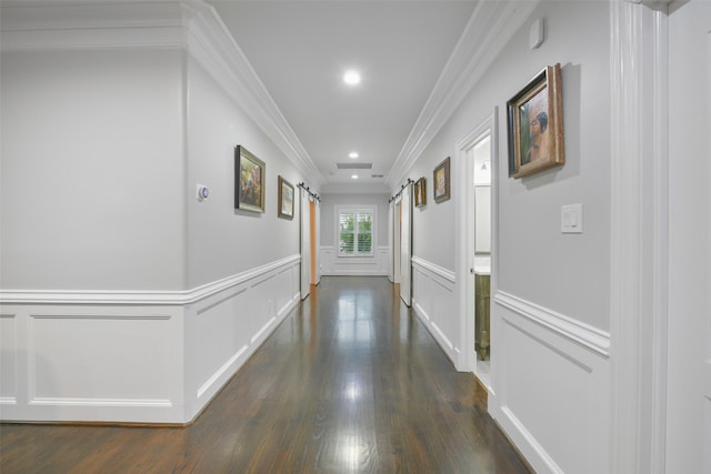 corridor with dark hardwood / wood-style flooring, a barn door, and ornamental molding