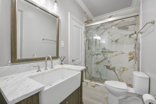 bathroom featuring vanity, toilet, a shower with shower door, and crown molding