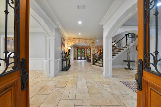 foyer entrance featuring ornate columns and ornamental molding