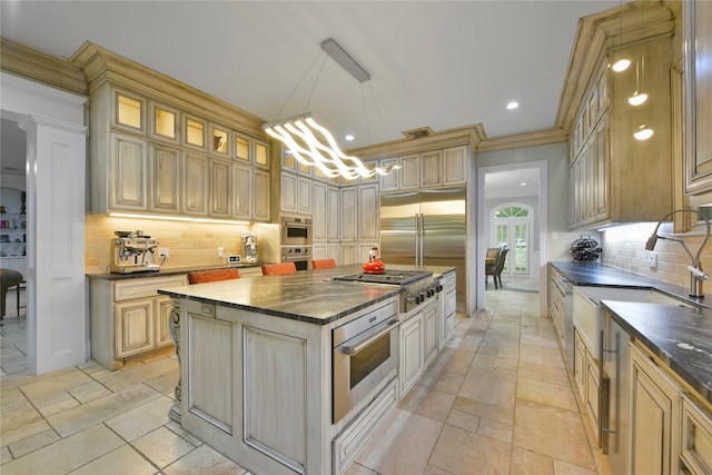 kitchen featuring decorative backsplash, a center island, hanging light fixtures, and appliances with stainless steel finishes