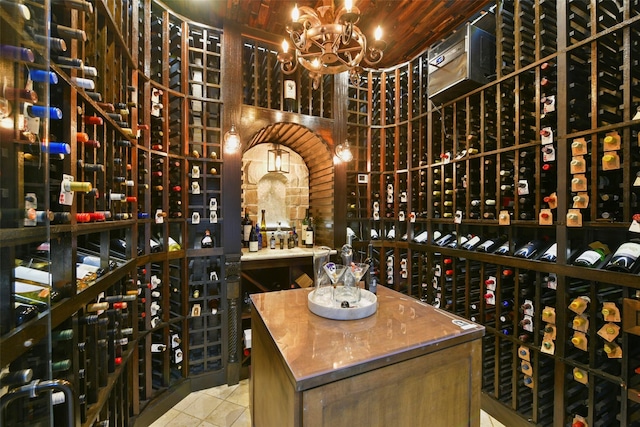 wine cellar with tile patterned flooring and a chandelier