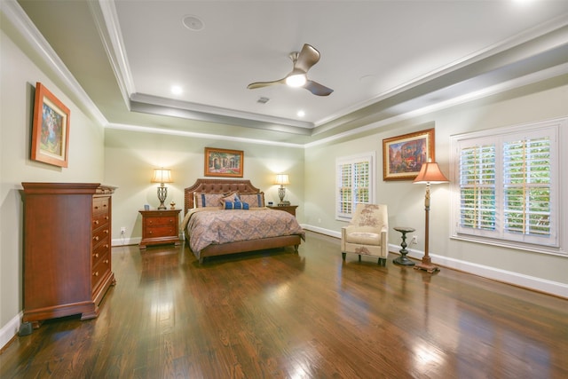 bedroom featuring ceiling fan, dark hardwood / wood-style flooring, ornamental molding, and a tray ceiling