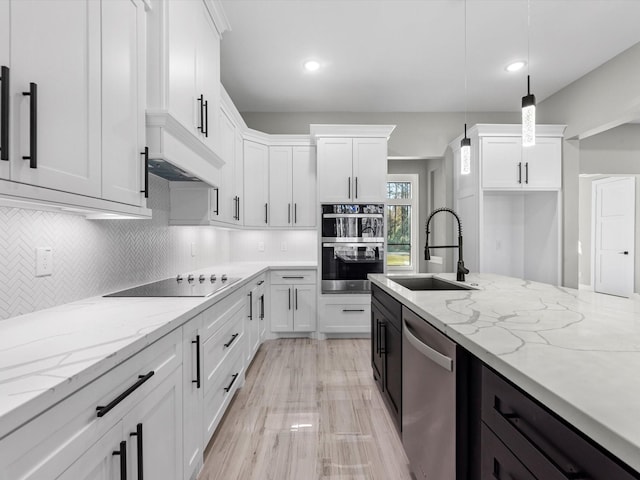 kitchen with white cabinets, decorative light fixtures, stainless steel appliances, and light stone countertops