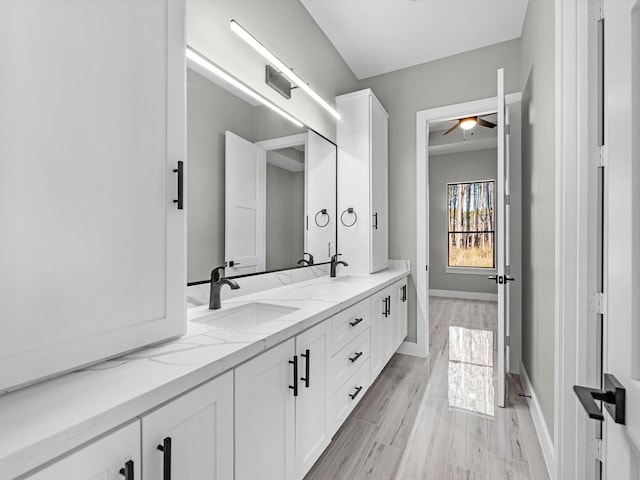 bathroom with hardwood / wood-style floors, vanity, and ceiling fan