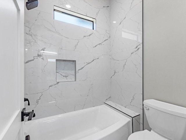 bathroom featuring toilet and tiled shower / bath