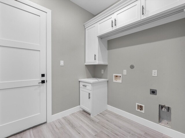 clothes washing area with washer hookup, electric dryer hookup, cabinets, and light wood-type flooring