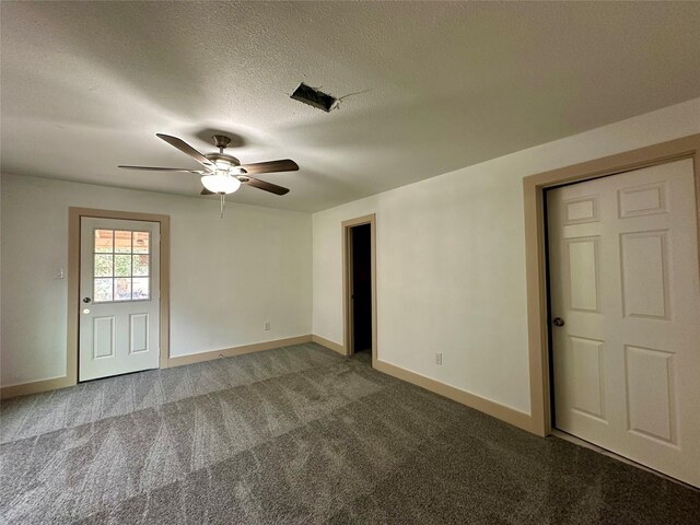 carpeted empty room featuring ceiling fan and a textured ceiling