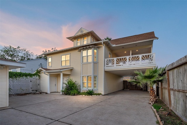 back house at dusk featuring a balcony