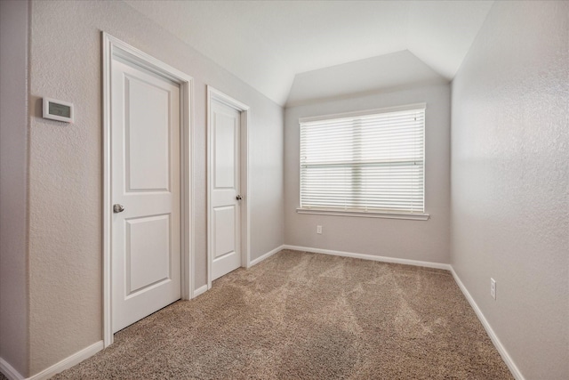 unfurnished bedroom featuring carpet floors and lofted ceiling