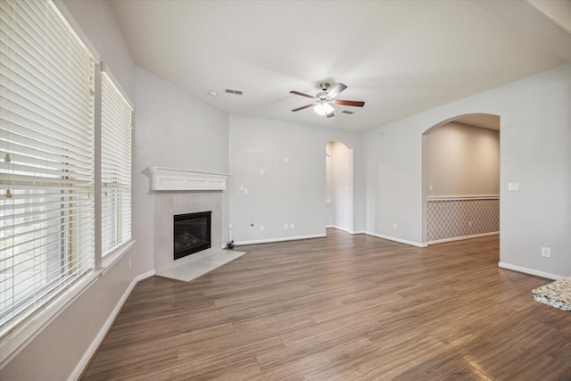 unfurnished living room with hardwood / wood-style flooring, ceiling fan, and a tile fireplace