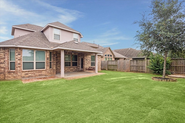 back of property with a patio area and a lawn