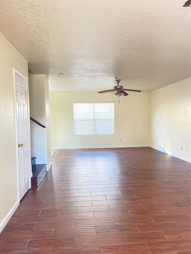 empty room with a textured ceiling and ceiling fan