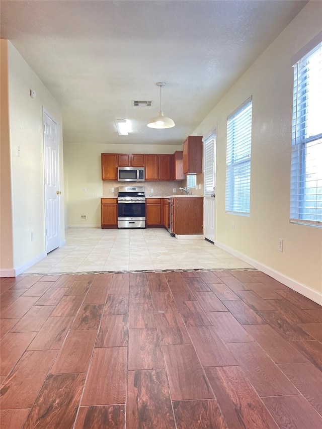 kitchen featuring pendant lighting, sink, stainless steel appliances, and tasteful backsplash