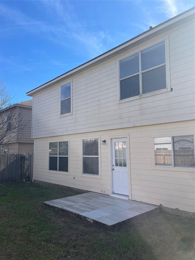 back of property with a patio and a lawn