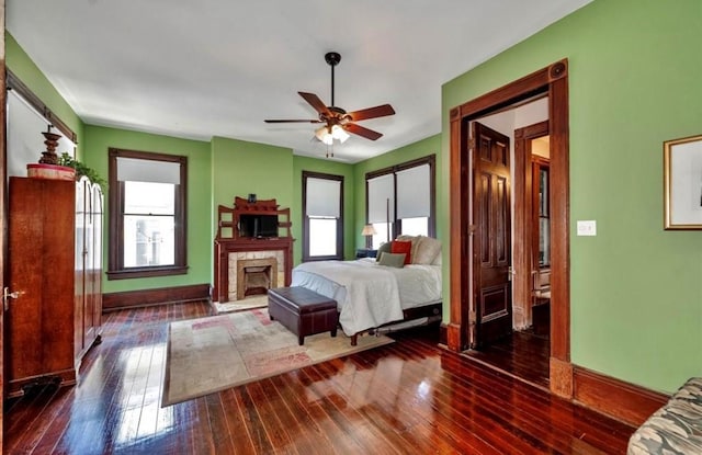 bedroom featuring multiple windows, ceiling fan, and dark wood-type flooring