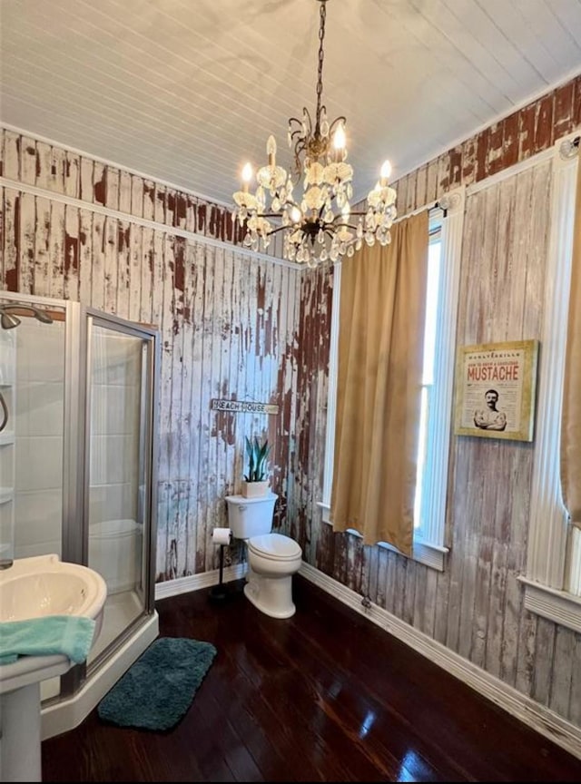 bathroom featuring walk in shower, wooden walls, a chandelier, hardwood / wood-style floors, and toilet