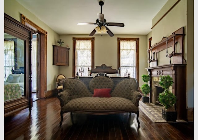 living area featuring ceiling fan and dark wood-type flooring