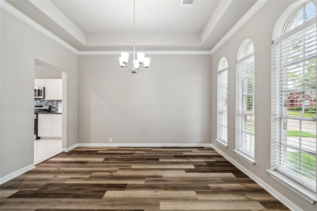 unfurnished dining area with a chandelier, dark wood-type flooring, and a tray ceiling